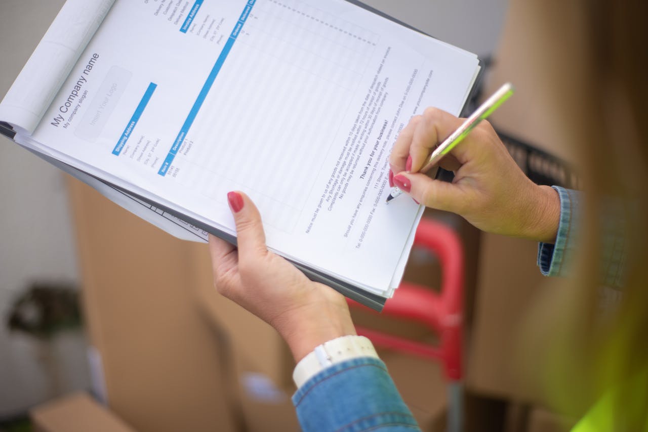 Close-up of woman's hand signing a document on a clipboard. Ideal for business and legal themes.